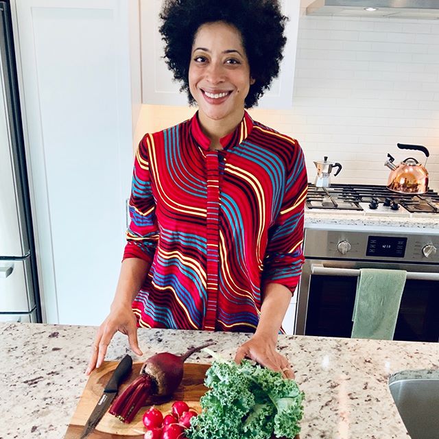 Dr. Stacy in front of a cutting board with vegetables on it